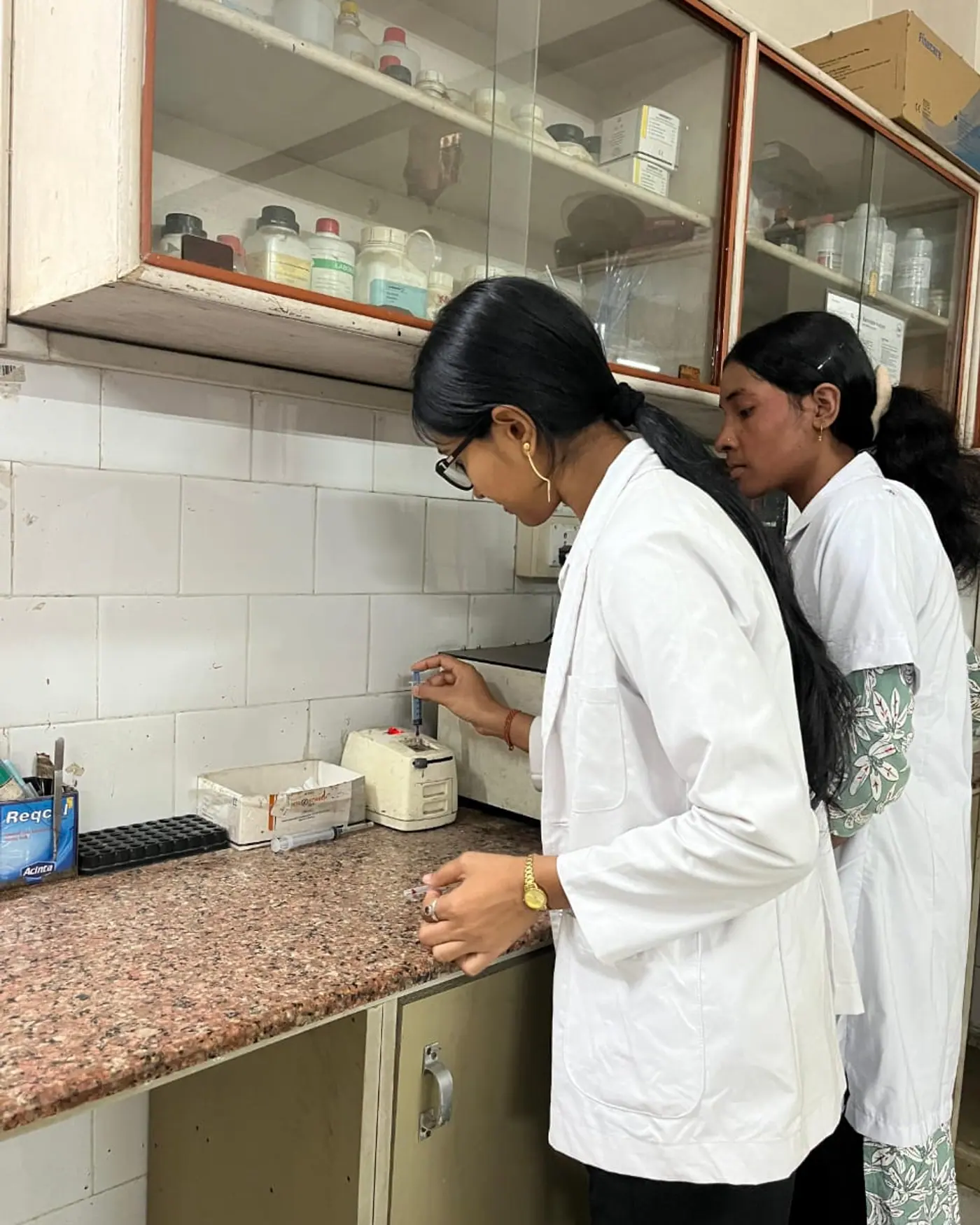 Two trainees running samples in a pathology lab